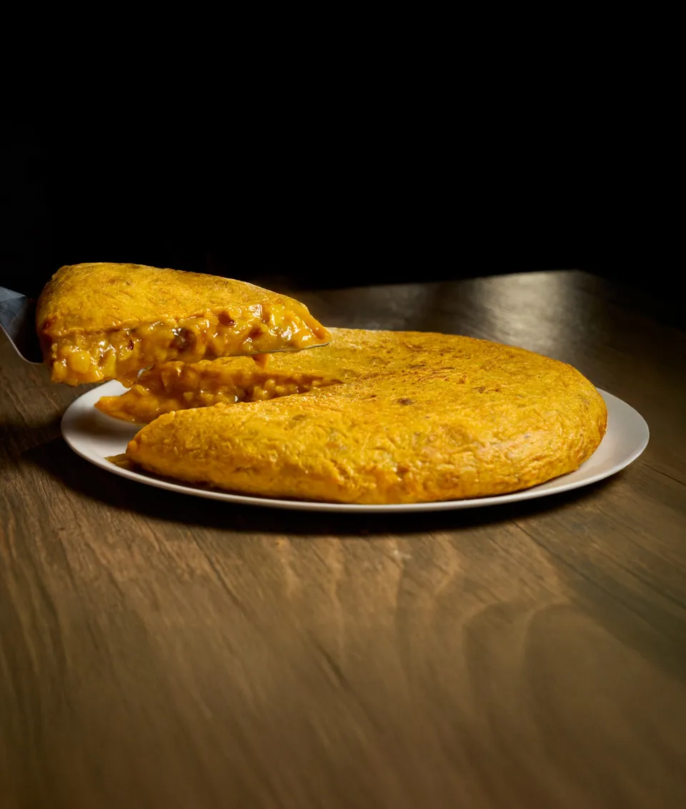 Tortilla Castiza entera, con un trozo cortado